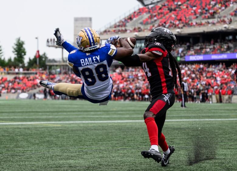 Two football players compete for a ball. 