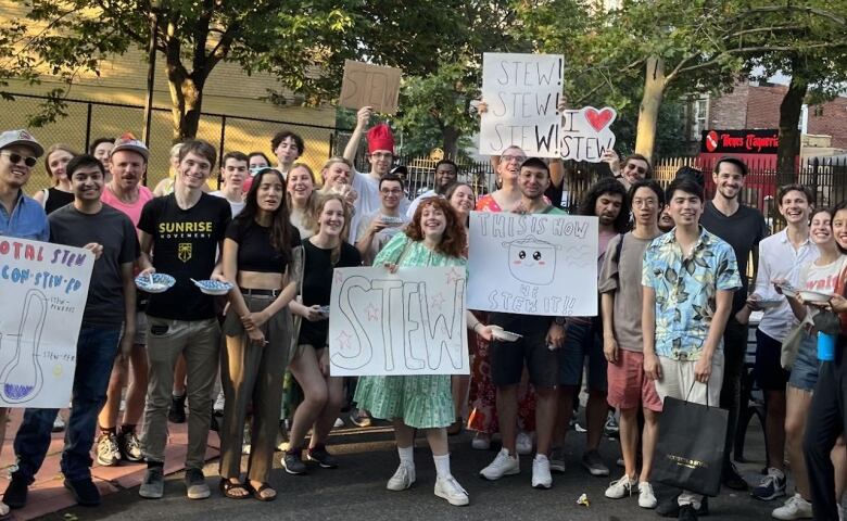 A group of people posing for a picture holding signs.