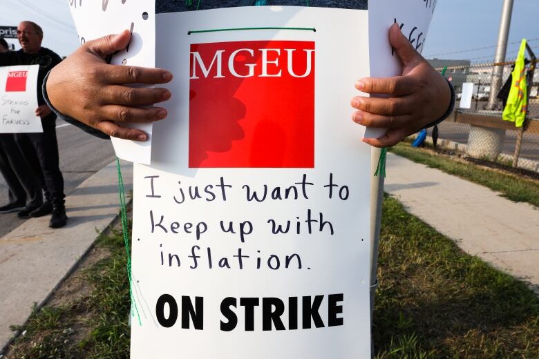 Close up of a striker's hands and sign, which says 