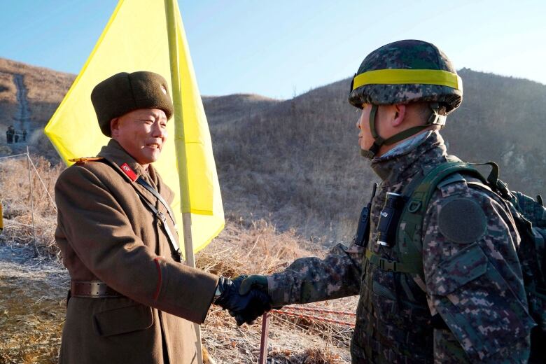 In this Wednesday, Dec. 12, 2018, file photo provided by South Korea Defense Ministry, South Korean army Col. Yun Myung-shick, right, shakes hands with North Korean army Lt. Col. Ri Jong Su before crossing the Military Demarcation Line inside the Demilitarized Zone (DMZ) to inspect the dismantled North Korean guard post in the central section of the inter-Korean border in Cheorwon. President Donald Trump is inviting North Korea's Kim Jong Un to shake hands during a visit to the demilitarized zone with South Korea. Trump is scheduled to visit South Korea later Saturday after meetings at the Group of 20 summit in Osaka, Japan. 