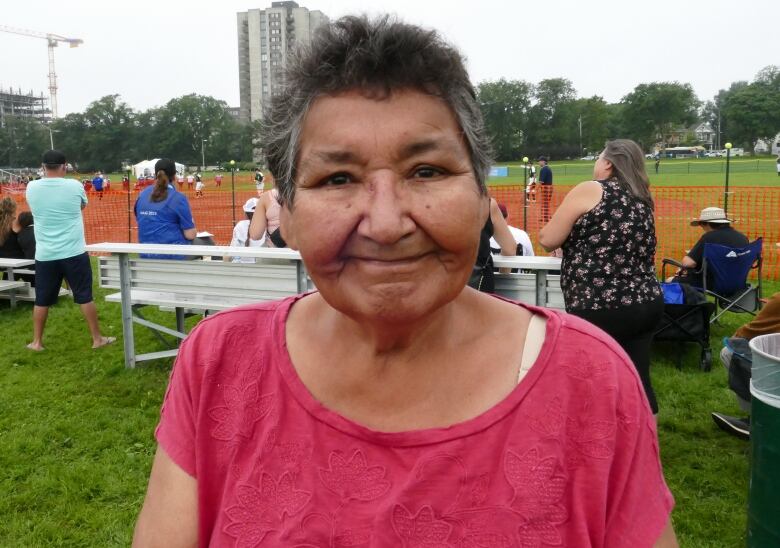 A First Nations woman from Cowessess stands at a sporting field in Halifax, Nova Scotia.