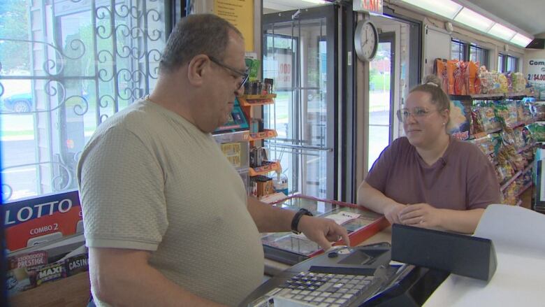 Customer Kaleigh Seegobin seen at check out with Peter Diab, co-owner of Expressway convenience store in Dartmount, N.S.