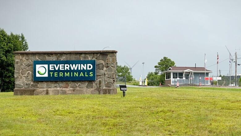 A sign on a lawn says 'Everwind Terminals,' with a security gate in the background.