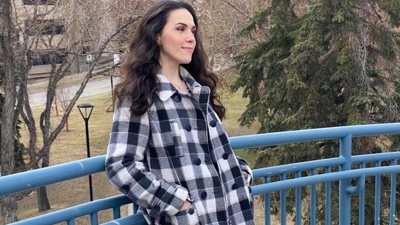 A lady with dark hair is seen in a checked shirt.