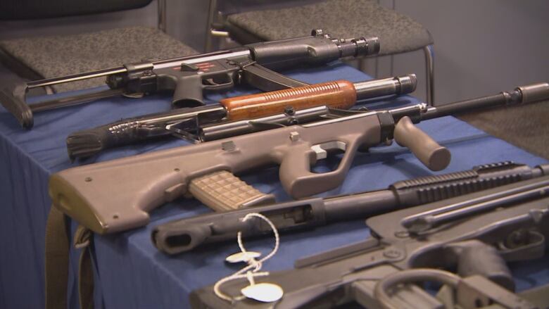 Assault weapons lie on display on a table