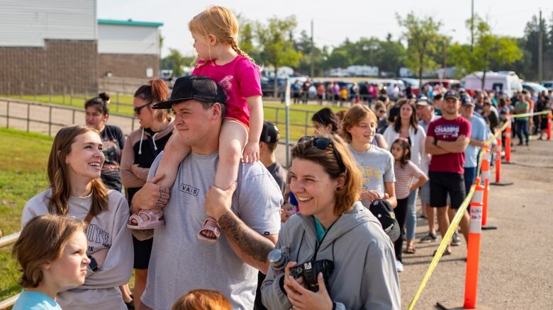 People wait in a long line outside.