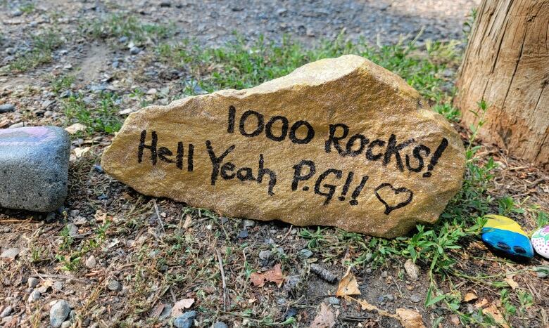 A gold-painted rock that says 