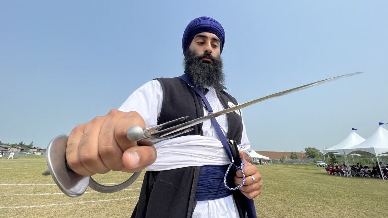 Rajbir Singh, organizer of Saturday's tournament, holds the kirpan, a ceremonial sword awarded to the winner of the Gatka tournament. Those older than 18 could compete on Saturday. 