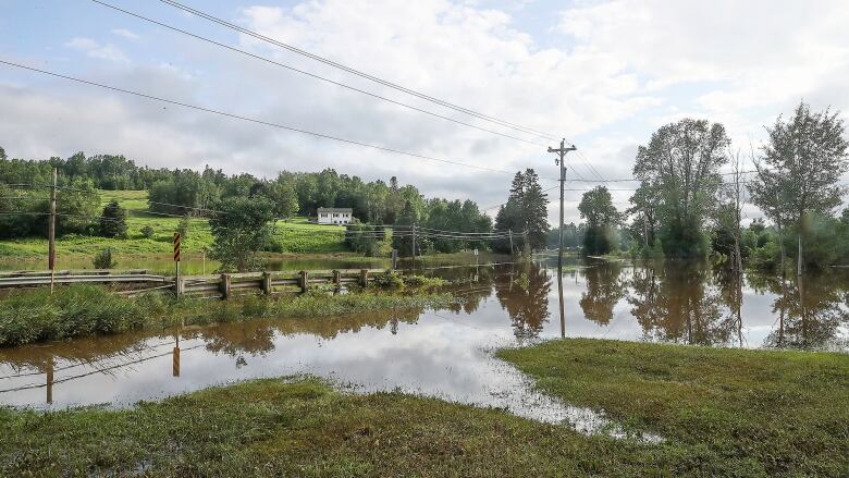 A small bridge in the countryside that is completely flooded.