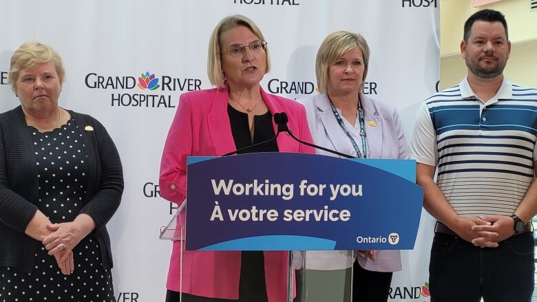 Woman at podium with people behind her