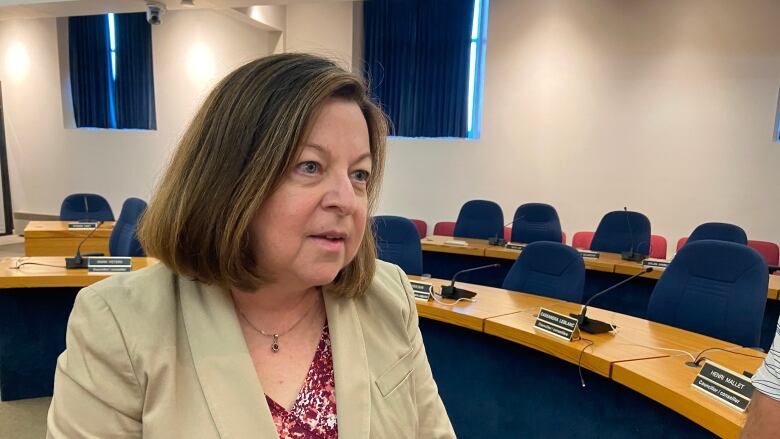 A woman wears a blazer inside Fredericton council chambers.