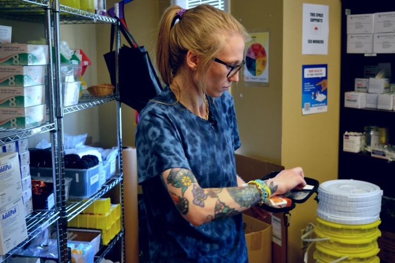 A woman opens a small bag with needles