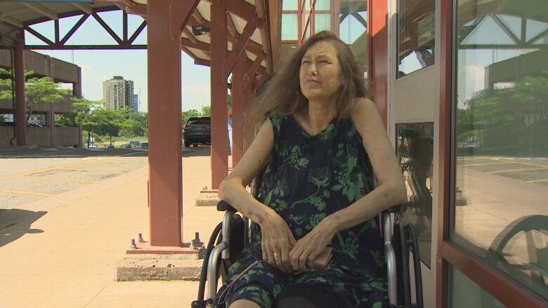 A woman in a wheelchair is next to a doorway.