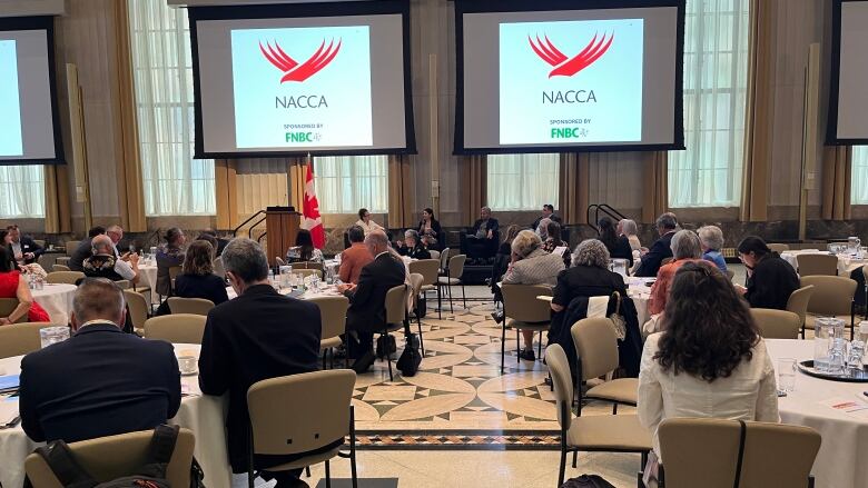 People at tables inside the Sir John A. Macdonald Building.