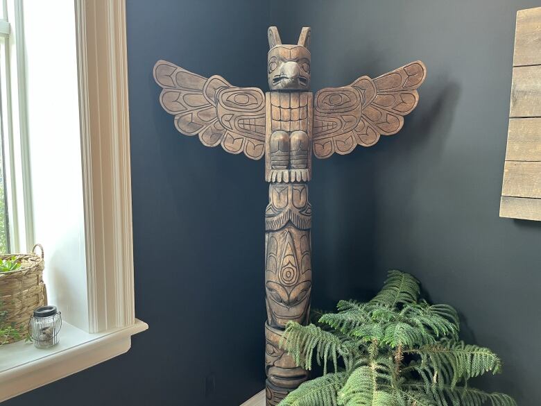 Totem pole against dark wall.