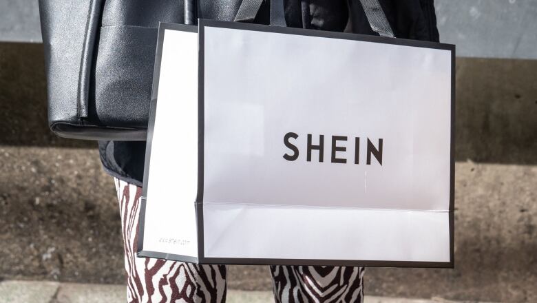 A white shopping bag branded with 'Shein'