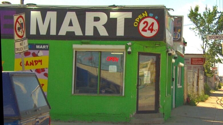 Green-painted storefront, with part of a sign showing the word 