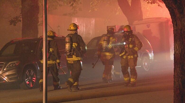 Firemen are pictured walking in red hazy air