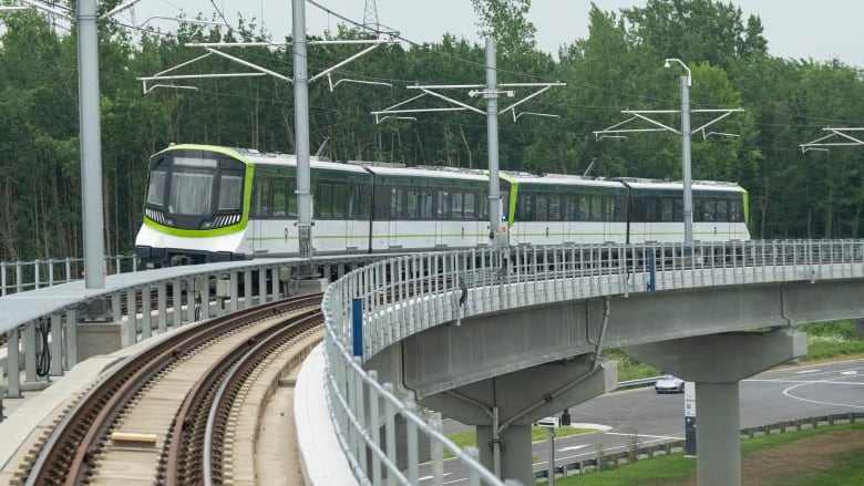 A train on a light rail system moves between stations.