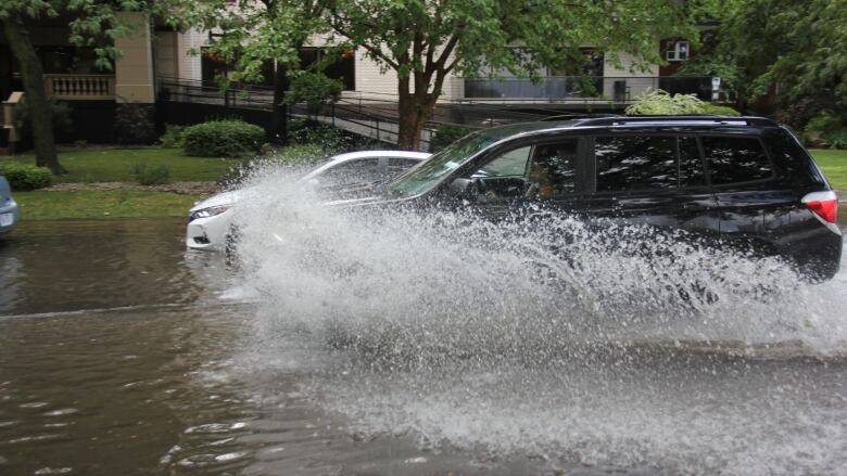 A car makes a splash through a puddle. 