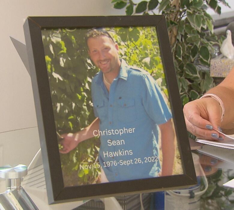 A framed photo of a man wearing a blue collar shirt