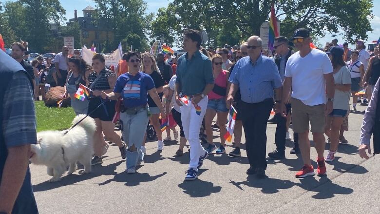 Prime Minister Justin Trudeau marches in the P.E.I. Pride parade Saturday alongside Pride P.E.I. board chair Lucky Fusca (left) and MP Lawrence MacAulay.