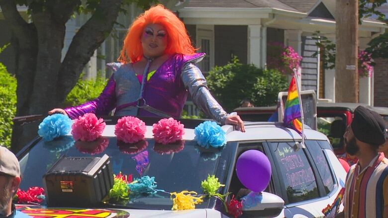 A drag queen in a car.