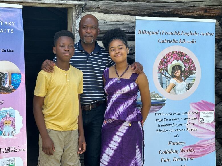 Left to right, Ange, Olivier, and Gabriella Kikwaki. Gabriella, 14, is a successful bilingual author who was invited to the Pioneer Village to display her work during the Emancipation Day celebration.