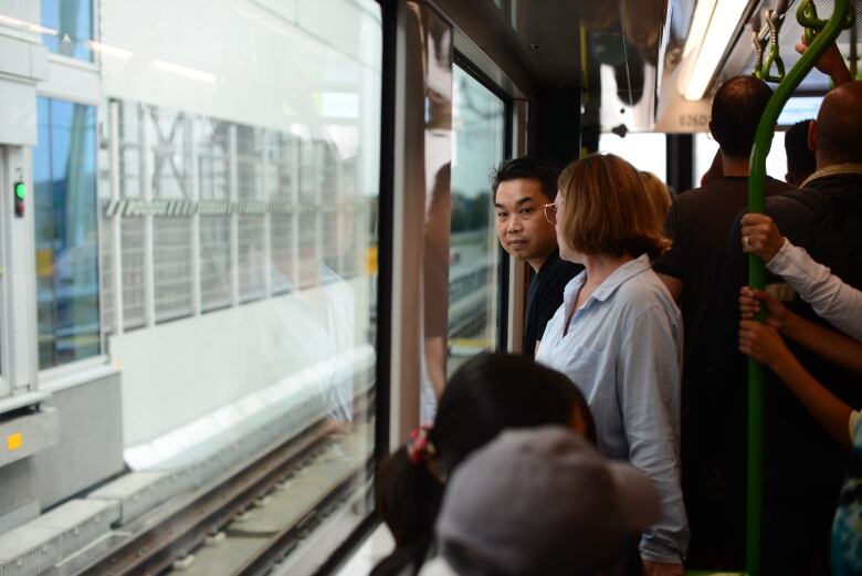 A man looks outside a train window.