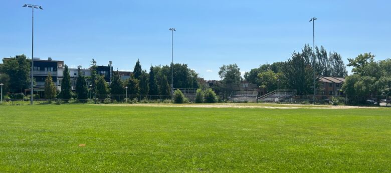 A grassy field with stands in the background.