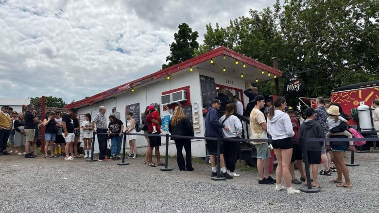 People line up outside a snack bar. 