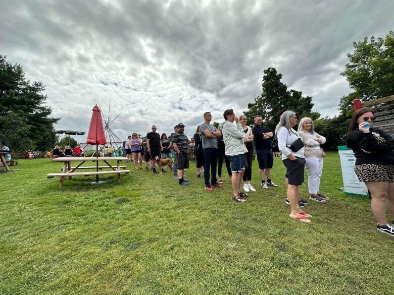 People line up on the grass. 