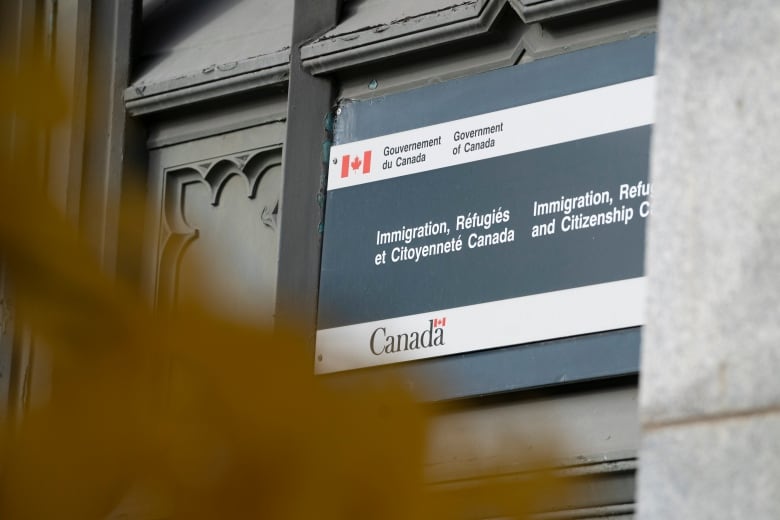 An Immigration, Refugees and Citizenship Canada sign is seen on the side of an old building in Montreal.