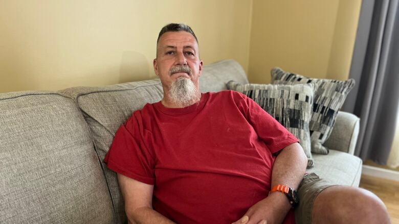 man in red t-shirt on couch