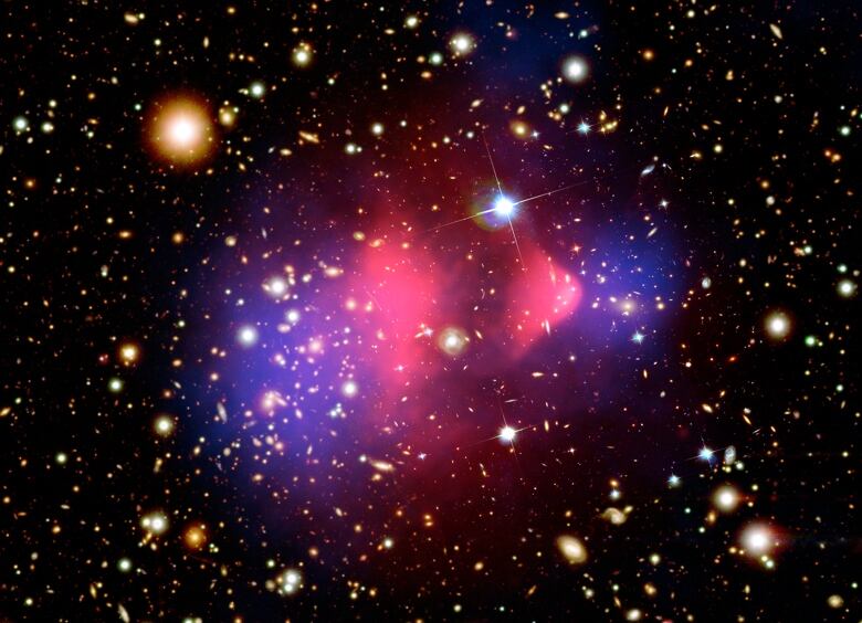 Clusters of glowing galaxies are peppered all over the screen with a pink and purple haze in the middle showing the collision of two galaxy clusters.