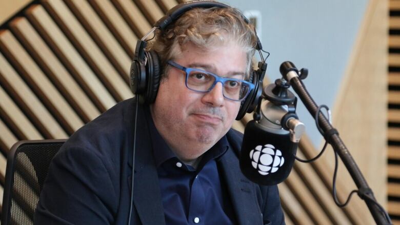 A man sits in front of a microphone.