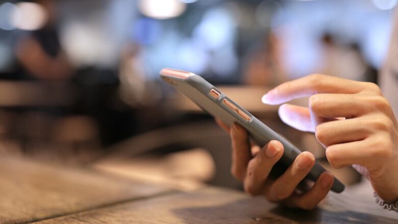 A person is pictured using a cellphone in a stock image. 