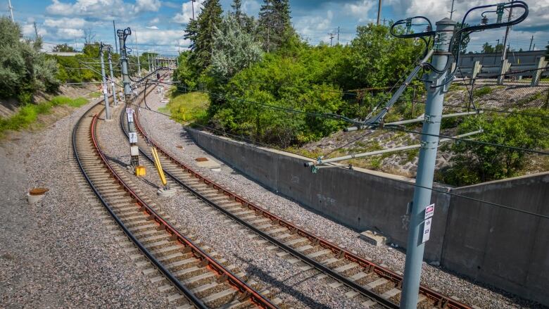 Rails curve off into the distance, with orange on an inner rail