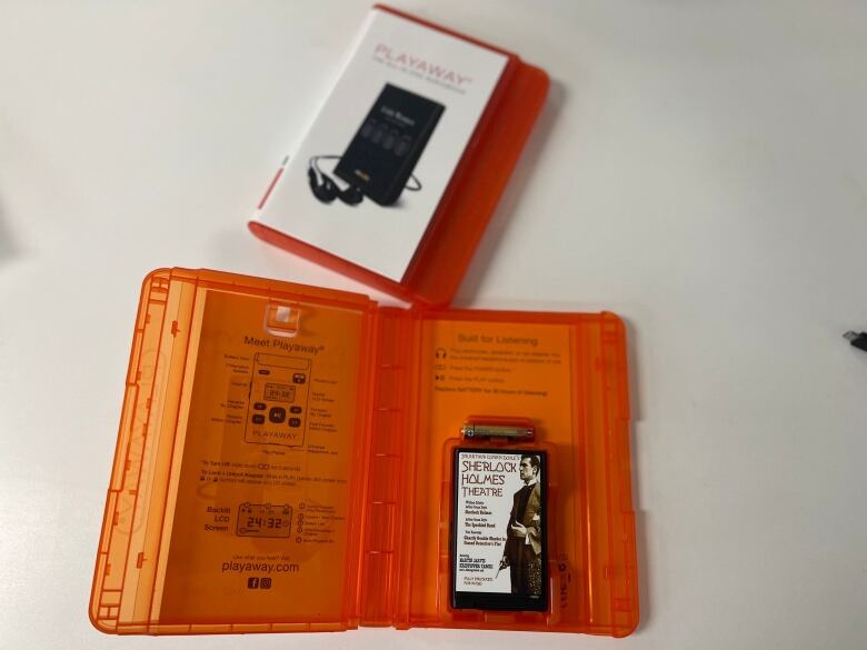 An orange case holds a small MP3 player that reads 