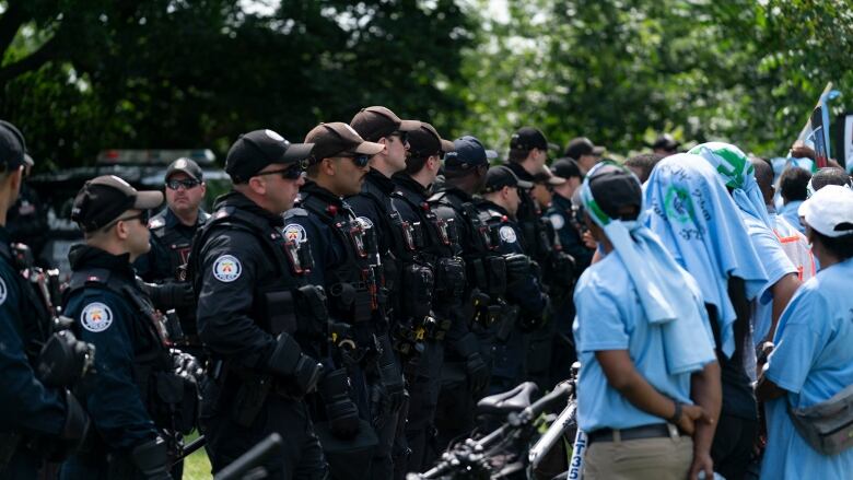 Toronto Police hold back a line of protestors in Earlscourt Park in Toronto, on Saturday, August 5 2023.