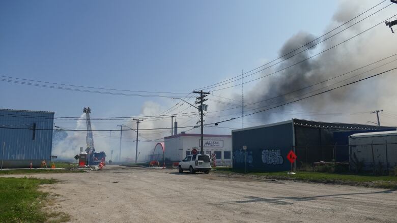 Smoke from the fire hangs low in the skies.