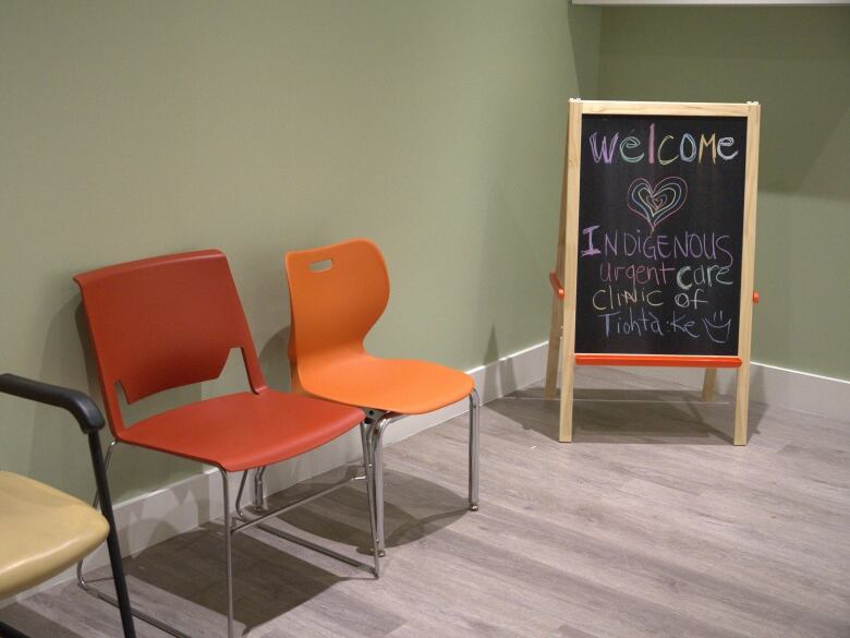 A waiting room with a chalkboard that reads, 