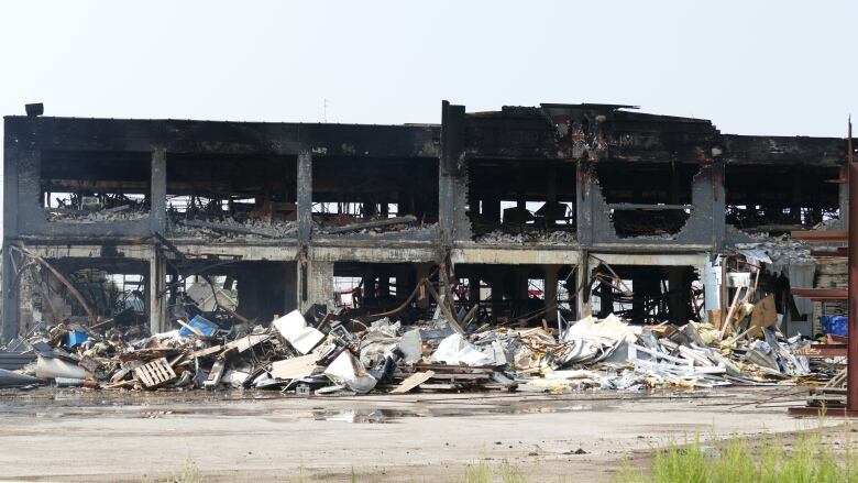 An exterior shot of a building that has been badly damaged by a fire. 