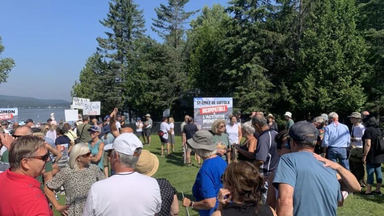 A crowd carries signs.