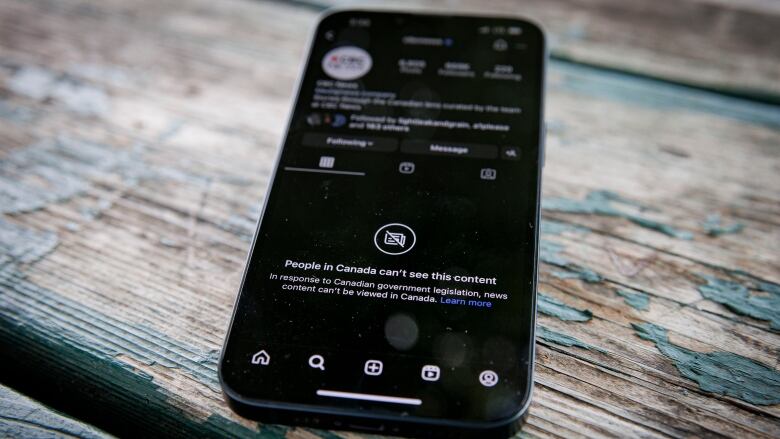 A phone screen shows a page on a social media app that reads, 'People in Canada can't see this content.'