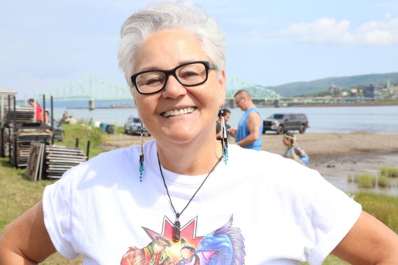 A woman smiles for a picture while outdoors.