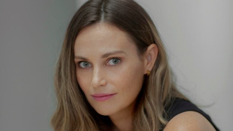 A woman wearing a black top poses for a portrait.