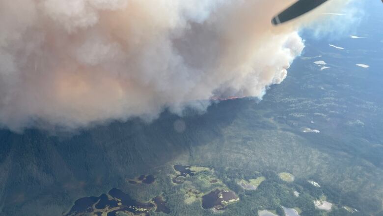 An aerial view of a wildfire burning on a remote hillside.