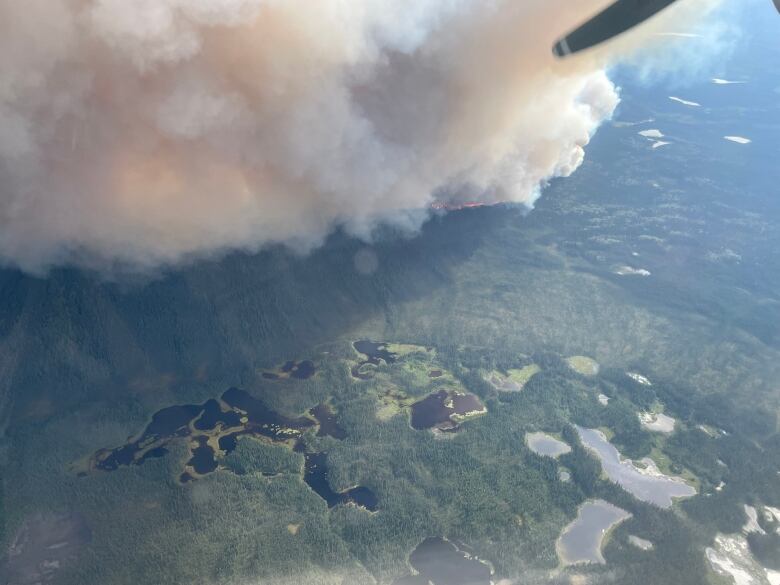 An aerial view of a wildfire burning on a remote hillside.