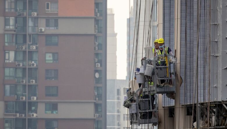 Men work at the construction site of an apartment building in Beijing, China, July 29, 2023. REUTERS/Thomas Peter